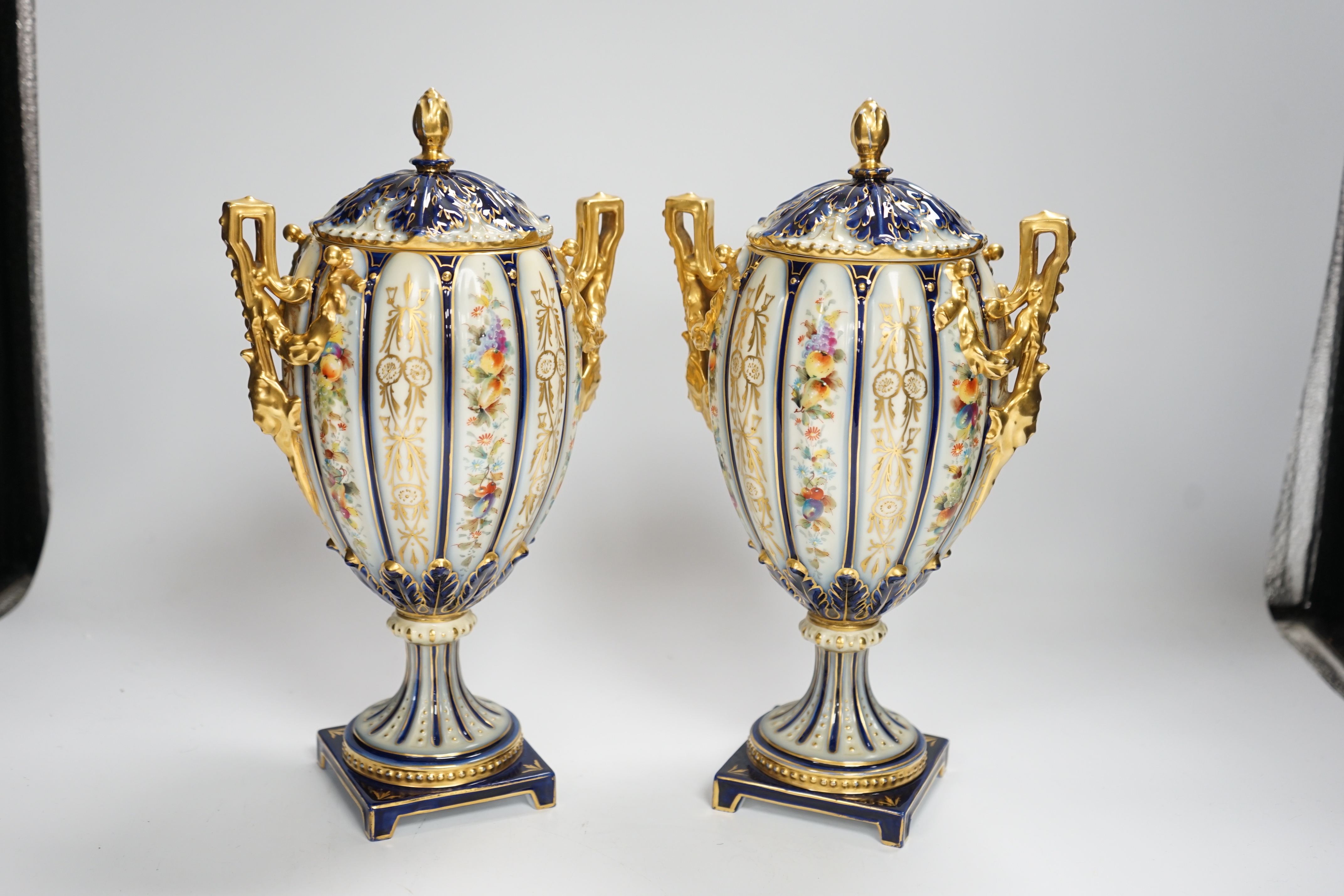 A pair of Rudolstadt gilt decorated urns and covers, 29cm